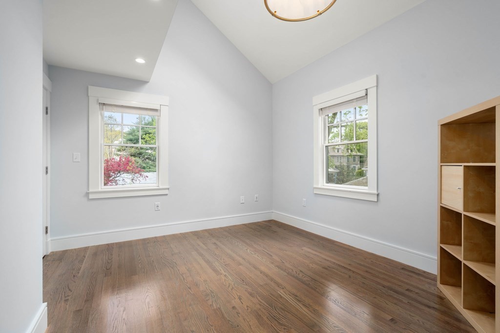 154 Spring Street, Unit 154 Watertown, MA 02472 - Photo 19 of 27 an empty room with wooden floor and windows