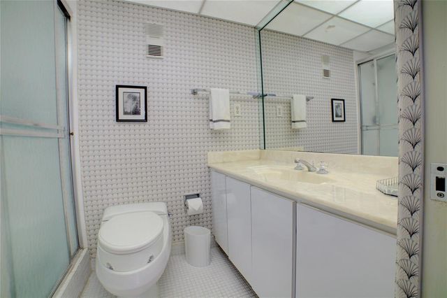 a bathroom with a granite countertop toilet and a sink