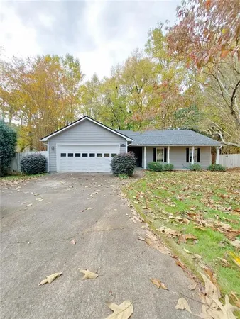 a view of a house with a yard and large tree
