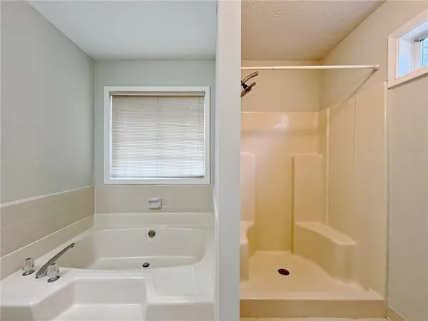 a bathroom with a shower and a bath tub