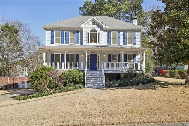 a front view of a house with a yard and potted plants
