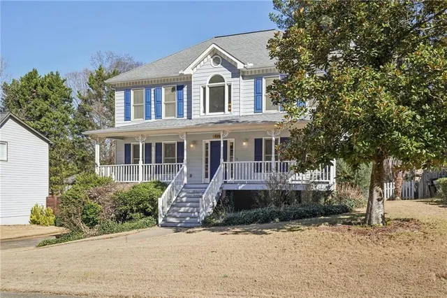 a front view of a house with a yard and potted plants