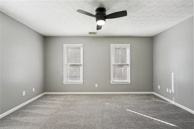 a view of a white house with a yard and furniture