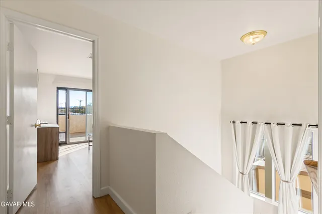 a view of a hallway with wooden floor and stairs