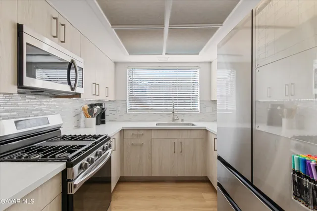 a kitchen with a sink stove top oven and cabinets