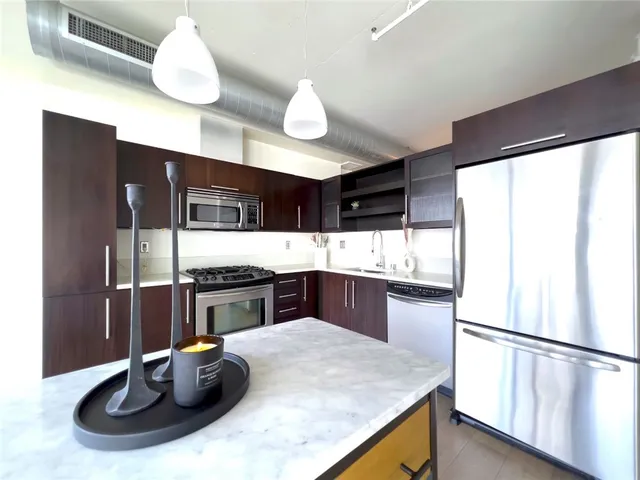 a kitchen with stainless steel appliances granite countertop a sink and a refrigerator