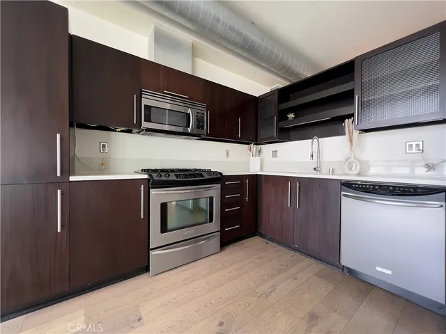 a kitchen with stainless steel appliances granite countertop a stove microwave and sink