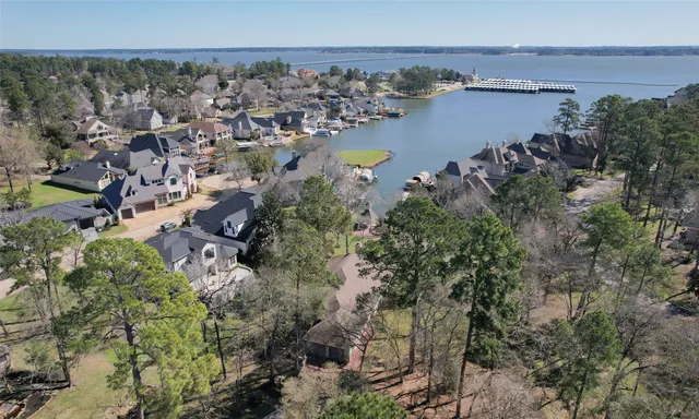 an aerial view of ocean and residential houses with outdoor space