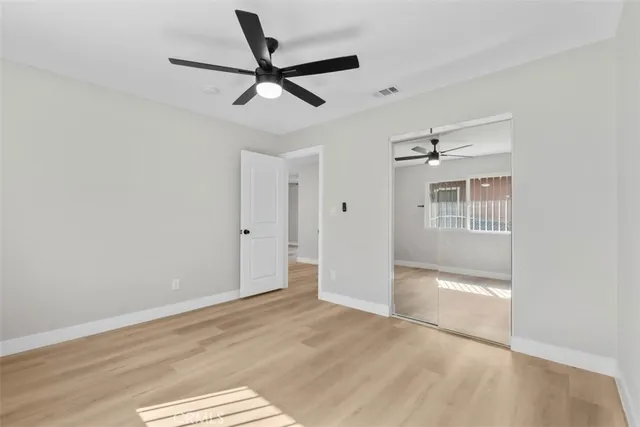 a view of a livingroom with a ceiling fan & entryway