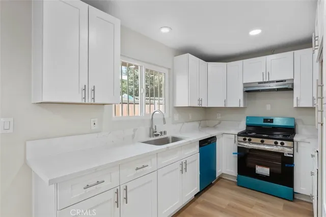 a kitchen with cabinets appliances a sink and a window