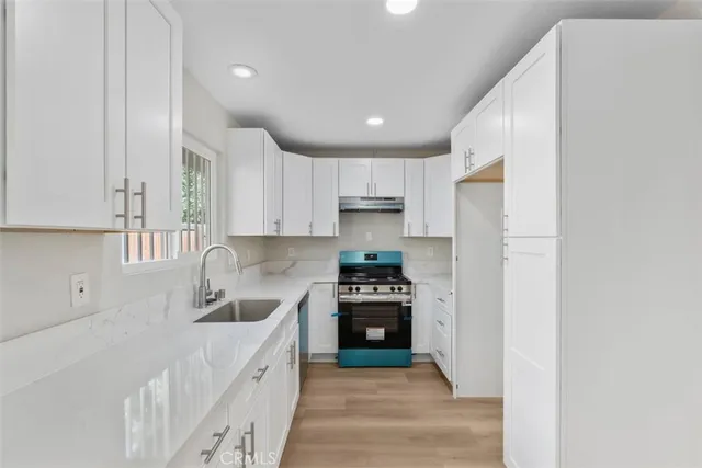 a kitchen with white cabinets and stainless steel appliances