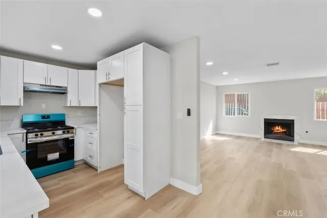 a kitchen with a refrigerator and a stove top oven