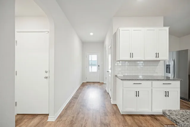 an empty room with wooden floor and cabinet