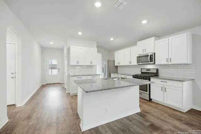 a kitchen with stainless steel appliances granite countertop a sink stove and cabinets