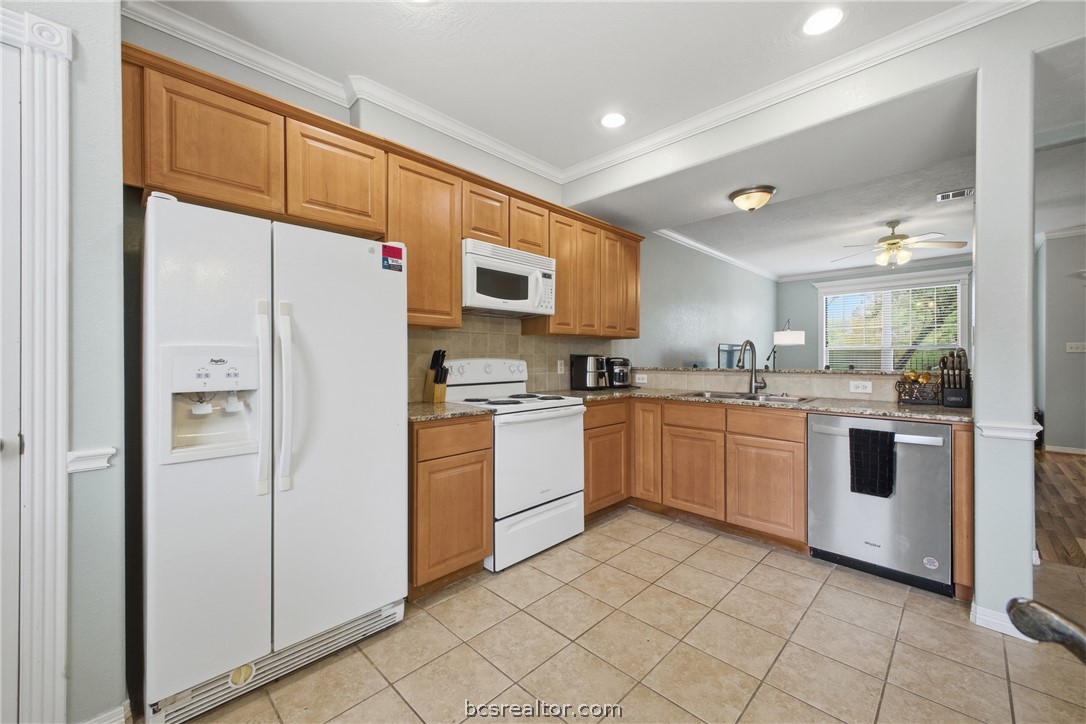 1000 Spring Loop, Unit 2105 College Station, TX 77840 - Photo 8 of 22 a kitchen with a refrigerator a sink and cabinets