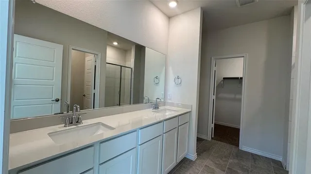 a bathroom with a double vanity sink and a mirror