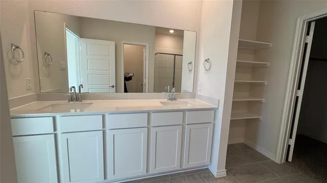 a bathroom with a double vanity sink and a mirror