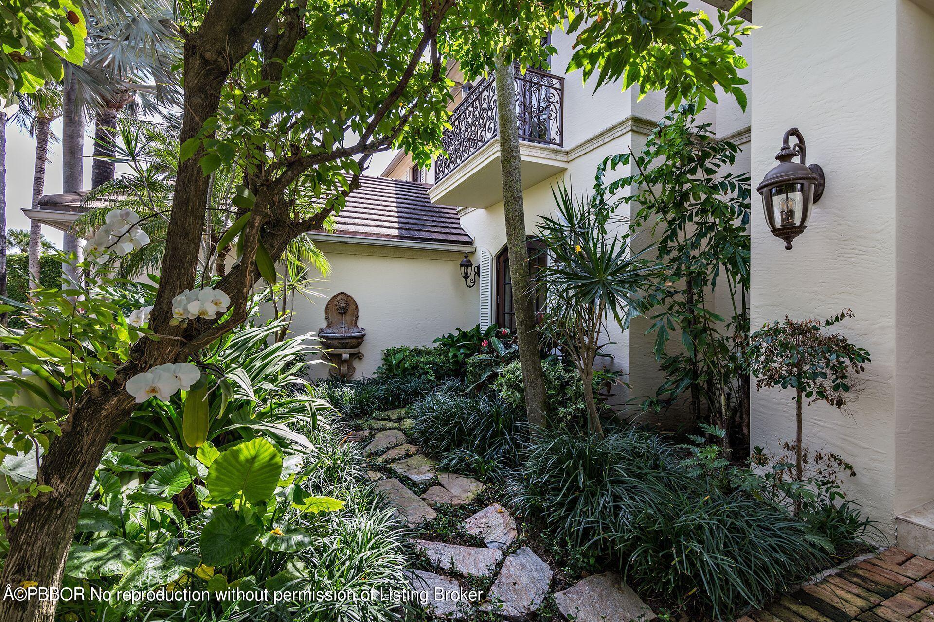 250 Country Club Road Palm Beach, FL 33480 - Photo 12 of 33 a front view of a house with a garden and a tree