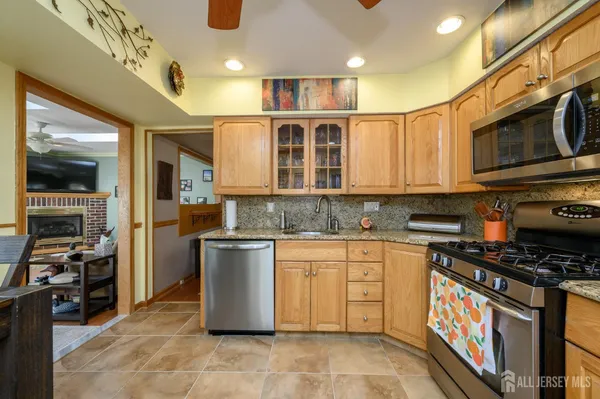 a kitchen with stainless steel appliances granite countertop a stove a sink and a microwave