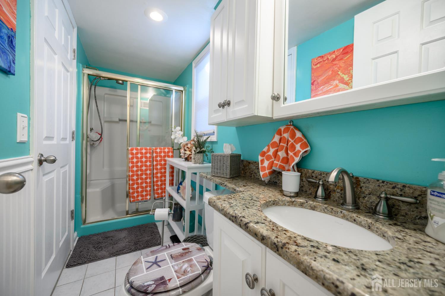 10 Eric Drive Howell, NJ 07731 - Photo 19 of 43 a bathroom with a granite countertop sink a mirror and shower