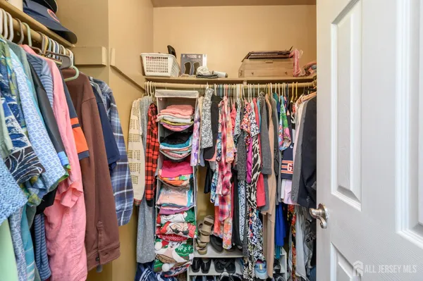 a view of walk in closet with clothes