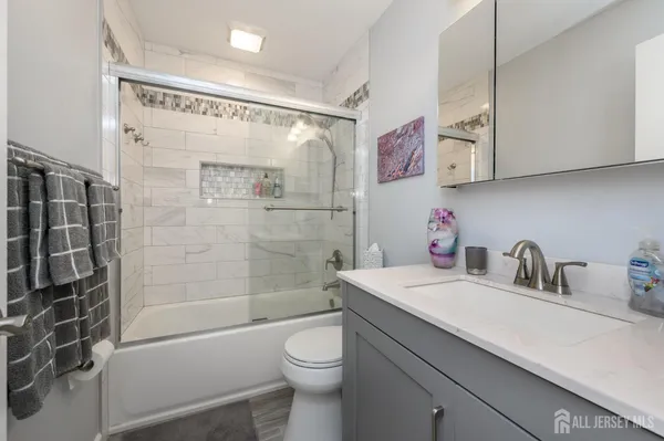 a bathroom with a sink a toilet and shower
