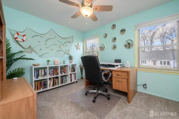 a view of a workspace with furniture and a window