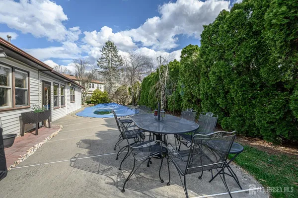 a view of a patio with table and chairs with wooden fence