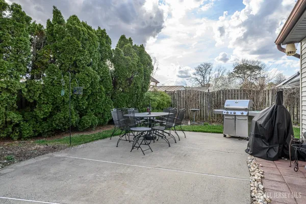 a view of backyard with table and chairs and a barbeque