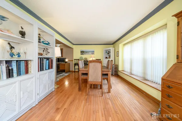 a dining room with wooden floor furniture and a window