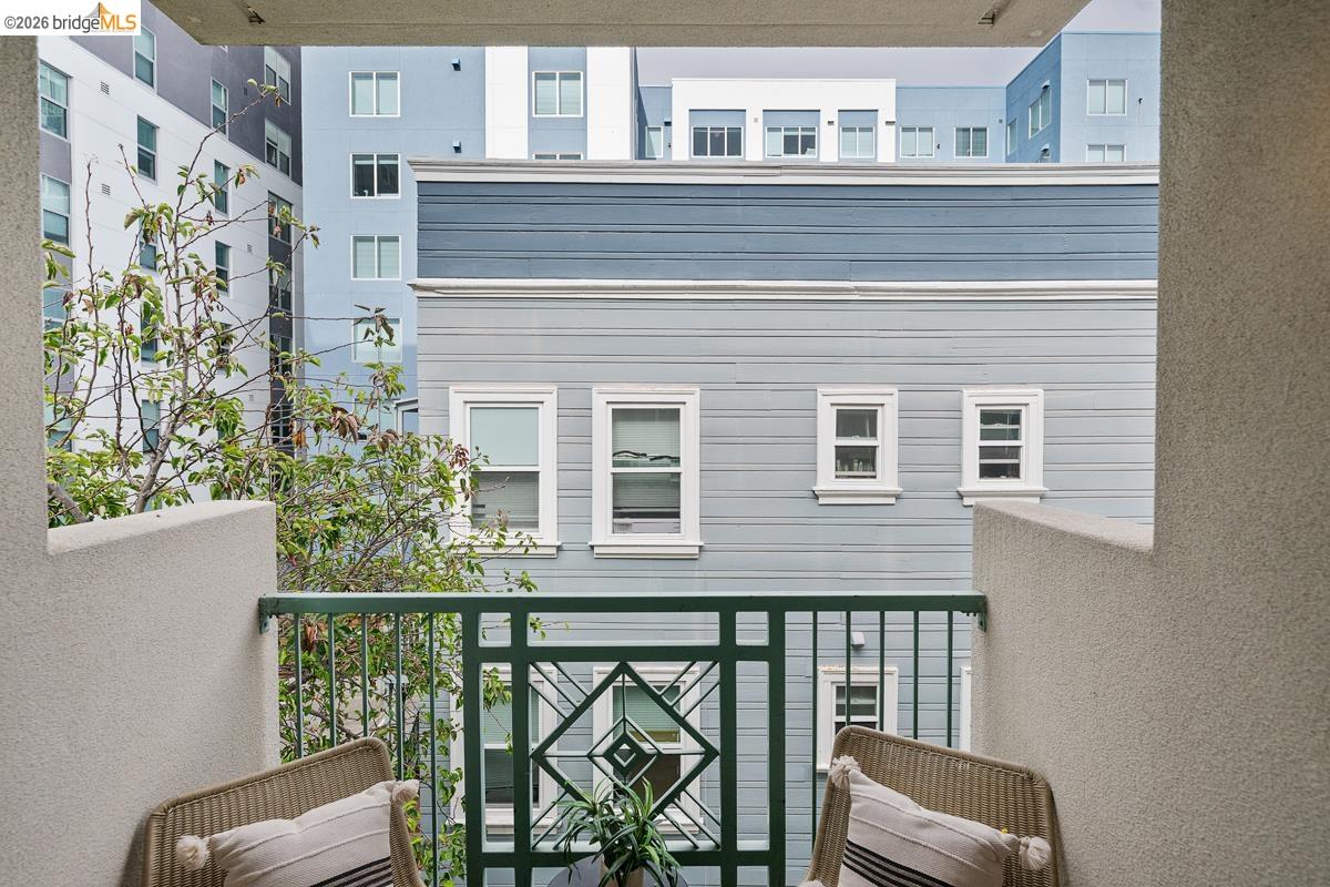 2029 Channing Way, Unit 3D Berkeley, CA 94704 - Photo 51 of 54 Balcony with a dark green metal railing featuring a geometric design, framed by textured light-colored stucco walls
