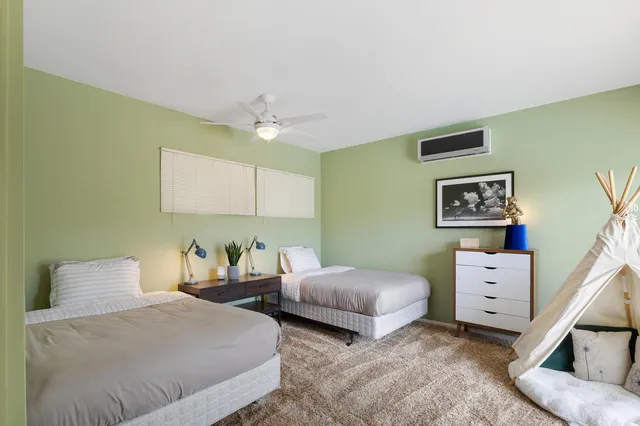 a bedroom with two beds and painting on the wall