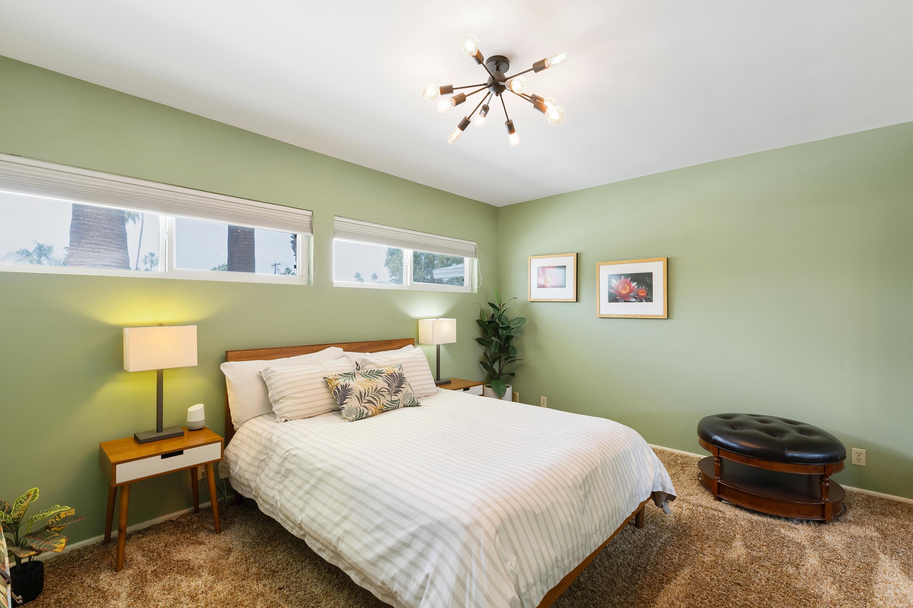 74533 Peppertree Drive Palm Desert, CA 92260 - Photo 27 of 34 a bedroom with a bed and a chandelier