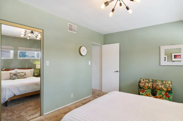 a bedroom with a bed and a painting on the wall