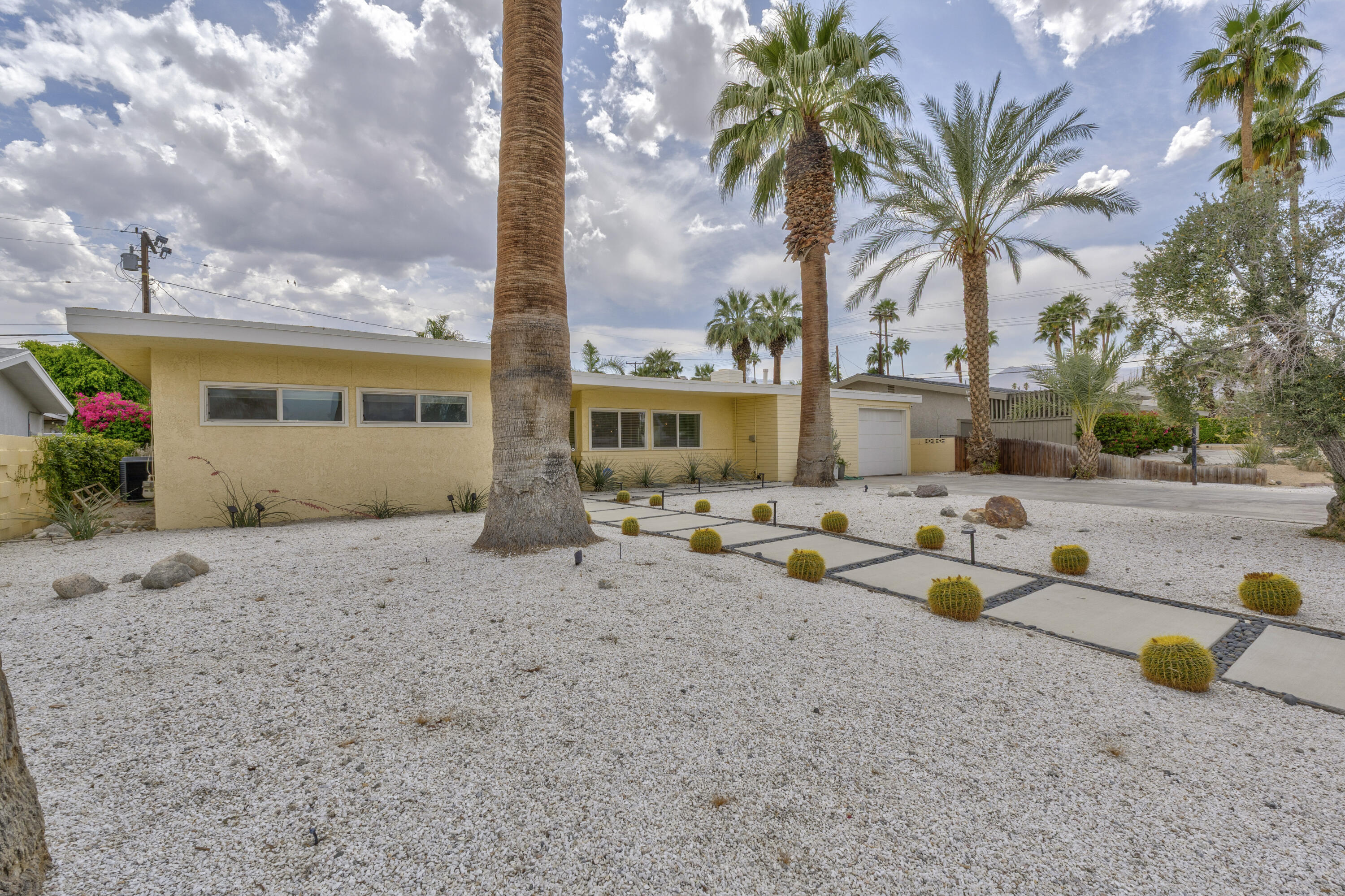 74533 Peppertree Drive Palm Desert, CA 92260 - Photo 3 of 34 a row of palm trees and swimming pool in the backyard of a house