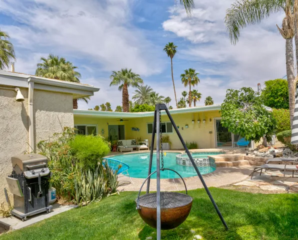 a view of a backyard with table and chairs potted plants