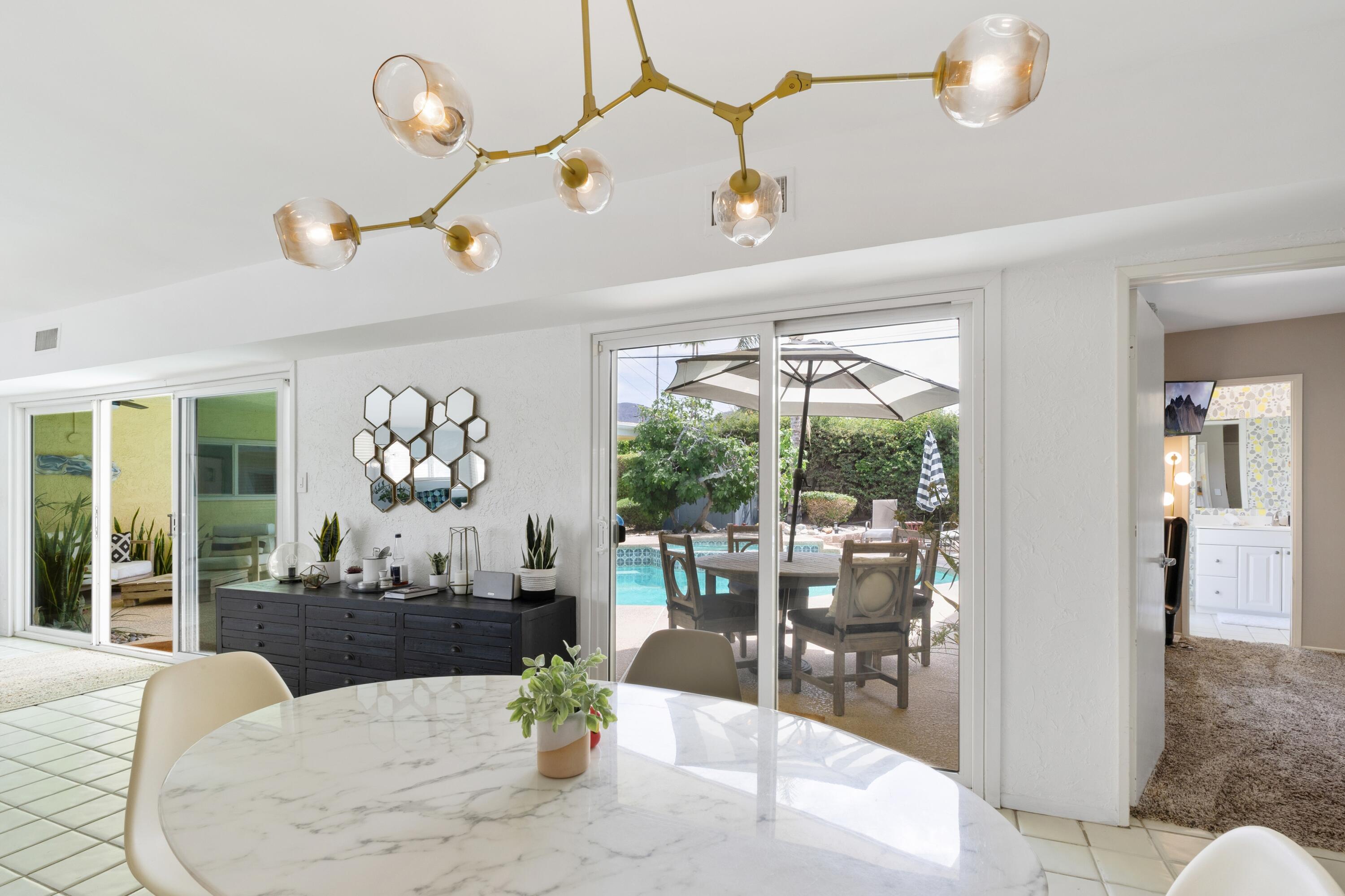 74533 Peppertree Drive Palm Desert, CA 92260 - Photo 10 of 34 a dining room with furniture a large window and a table