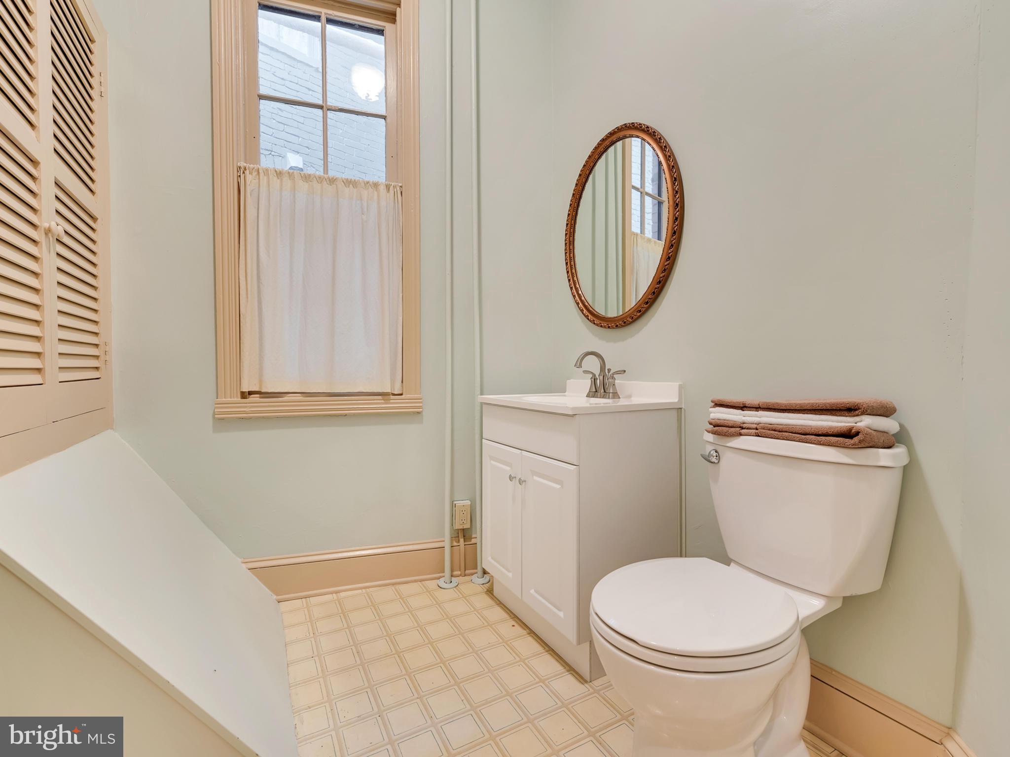 123 East 3rd Street Frederick, MD 21701 - Photo 7 of 28 a bathroom with a toilet a sink and a mirror