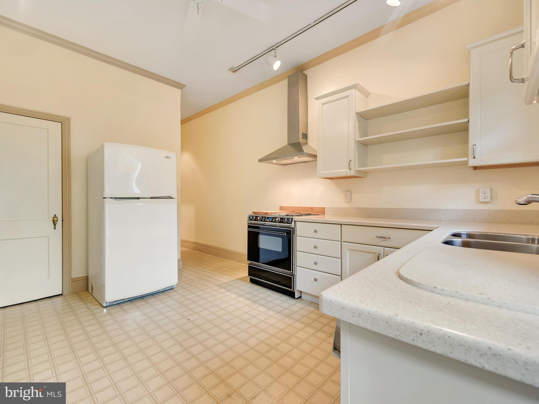 123 East 3rd Street Frederick, MD 21701 - Photo 10 of 28 a kitchen with a refrigerator and a stove top oven