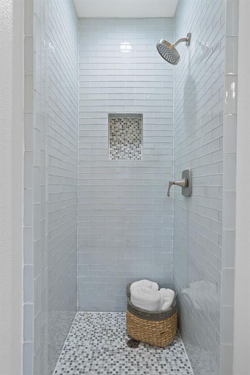 5211 Halmark Drive Austin, TX 78723 - Photo 15 of 27 A streamlined shower enclosure features elegant tile work and an integrated niche for toiletries.