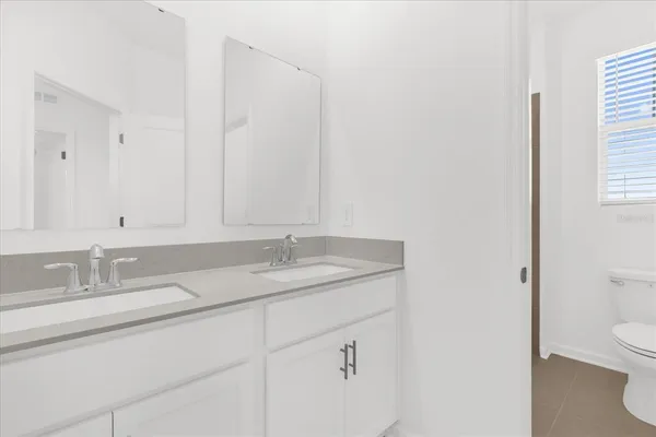 a bathroom with a granite countertop sink and a toilet