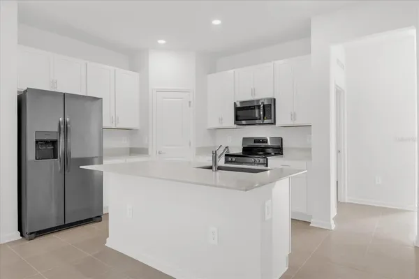 a kitchen with stainless steel appliances a refrigerator a stove a microwave and a sink