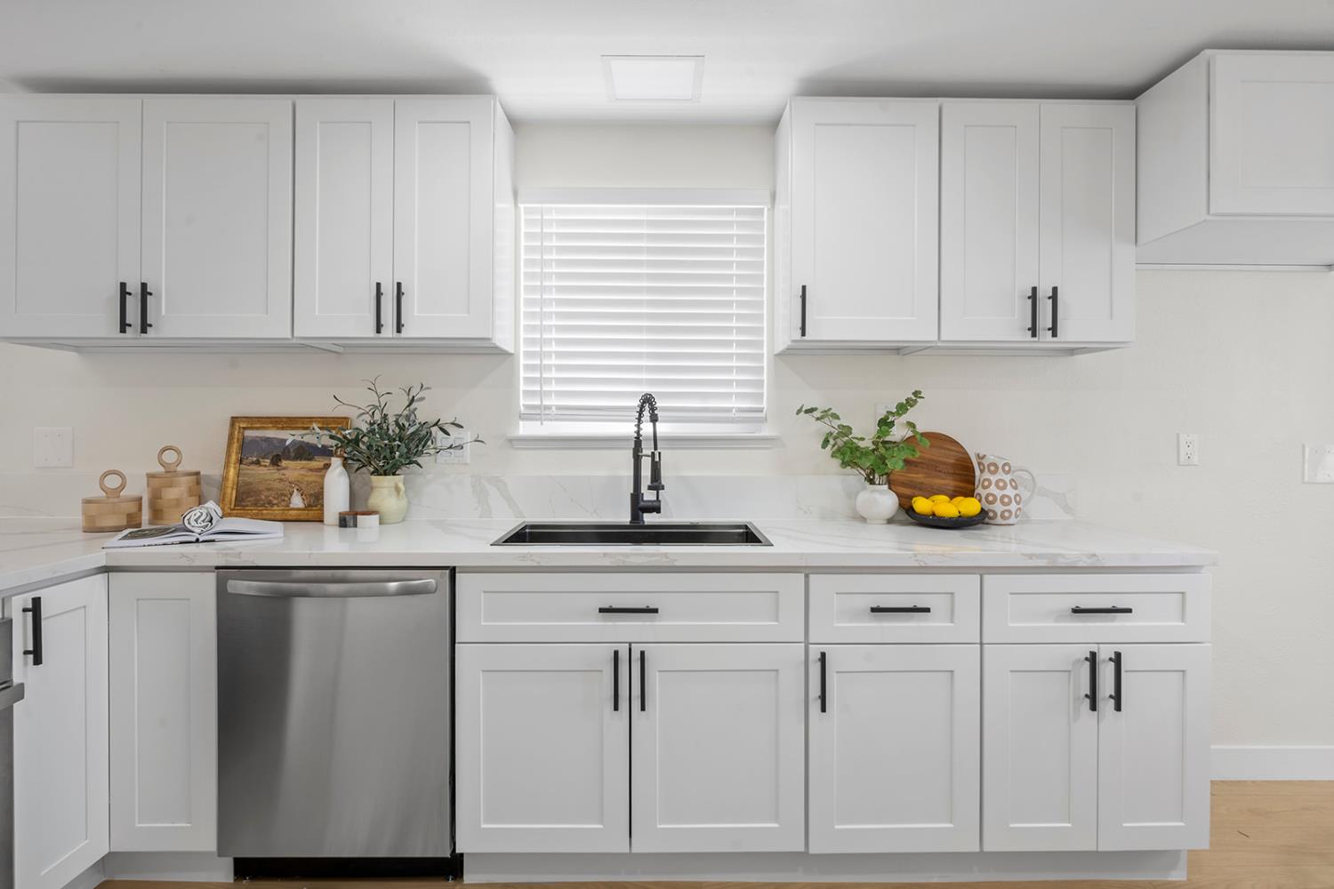 7531 Event Way Sacramento, CA 95842 - Photo 11 of 36 kitchen with dishwasher, white cabinetry, quartz counters, and laminate floors