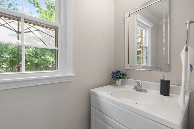 a bedroom with a bed and a mirror on the dresser