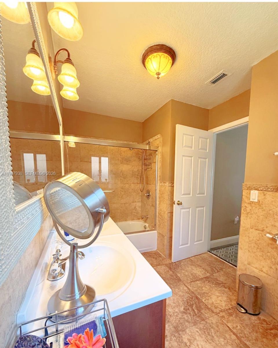 14856 Southwest 174th Street Miami, FL 33187 - Photo 13 of 28 a bathroom with a mirror and a shower
