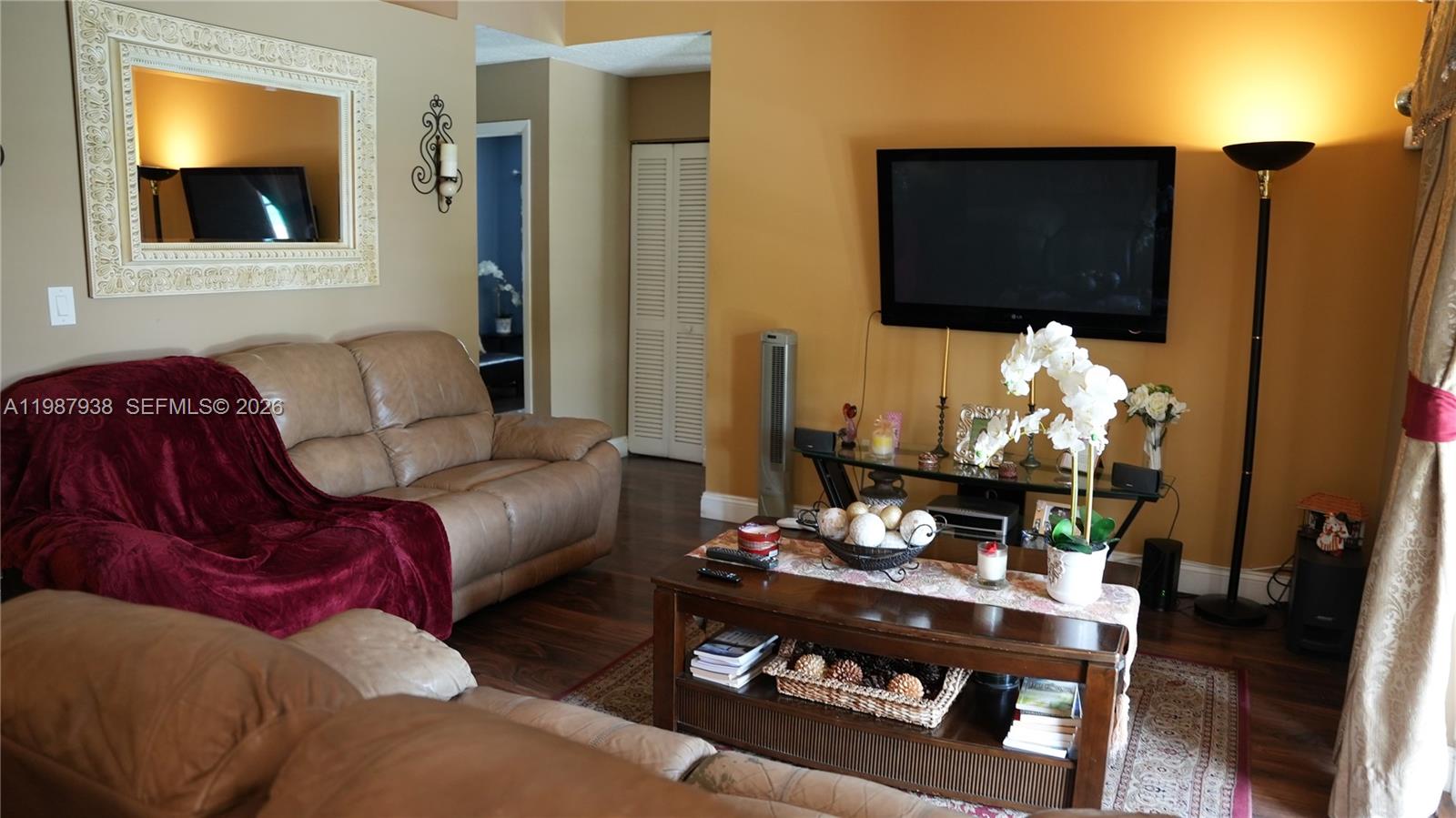 14856 Southwest 174th Street Miami, FL 33187 - Photo 19 of 28 a living room with furniture a flat screen tv and kitchen view