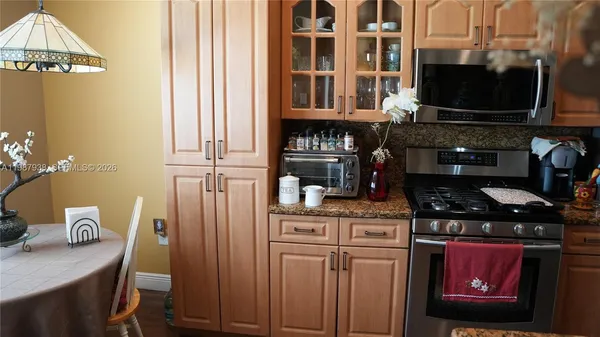 a kitchen with stainless steel appliances a stove a chimney a dining table and chairs