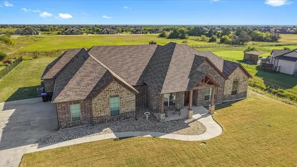 an aerial view of a house with a swimming pool and outdoor space