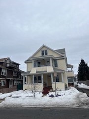 a view of a big house with wooden fence