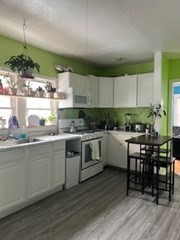 491-493 Newbury Street Springfield, MA 01104 - Photo 5 of 16 a kitchen with a table chairs stove and cabinets